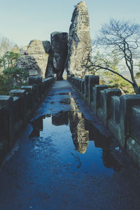 Reflection of built structure in water against sky