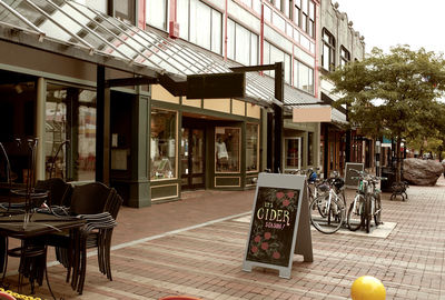 Chairs on table by street in city