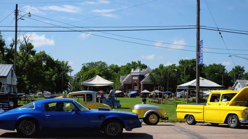 Cars on street in city against sky