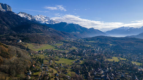 Scenic view of townscape by mountains against sky