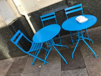 High angle view of empty chairs and tables at sidewalk cafe