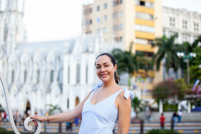 Beautiful tourist woman at the ortiz bridge with la ermita church on background in the city of cali