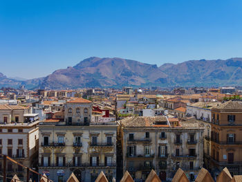 Houses in town against clear blue sky