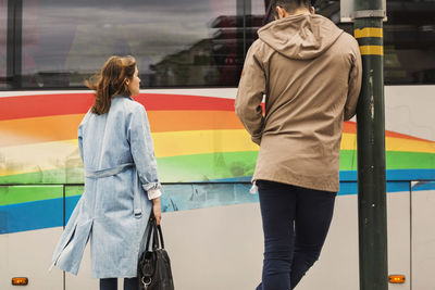 Rear view of people walking on road