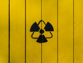 Sign of radiation on a yellow wooden board. radioactive sign - symbol of radiation. yellow and black