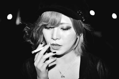 Portrait of young woman smoking cigarette