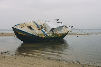 Abandoned ship moored at beach