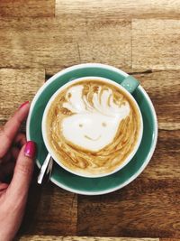 Close-up of woman holding cappuccino