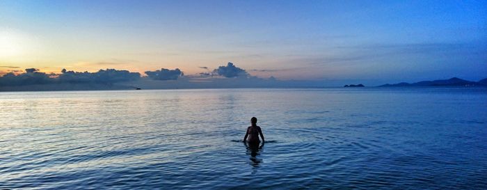 Silhouette of person standing in calm sea