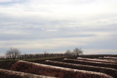 View of field against cloudy sky