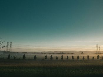 Silhouette of farm against sky