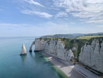 Steep white cliffs descending into the ocean in normandy, etretat.