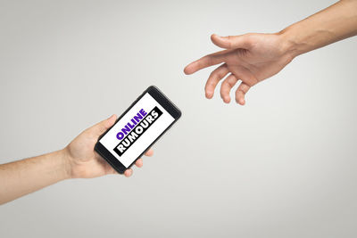 Midsection of person using smart phone against white background