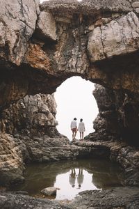 Rear view of couple standing at rock formation