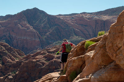 Rear view of backpack man hiking on rocky mountains