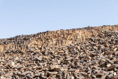 Low angle view of rocks against clear sky