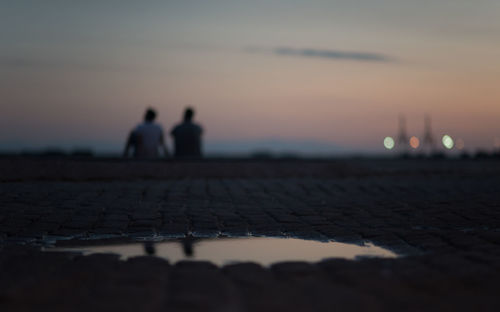 Silhouette people standing on beach against sky during sunset