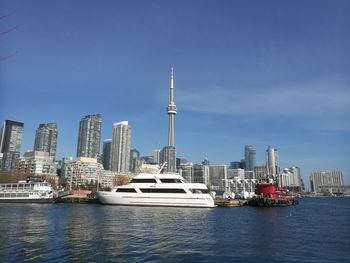 Modern buildings by river against sky in city