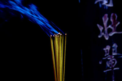 Close-up of candle against black background