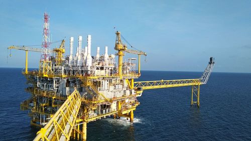 Offshore platform in sea against blue sky