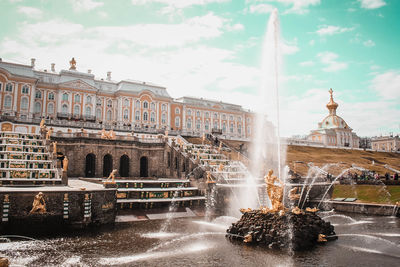 Fountain in city against sky