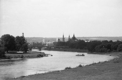 Boats moored in river with buildings in background