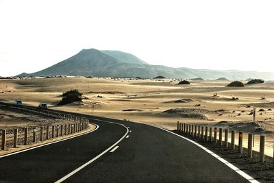 Empty road leading towards mountains