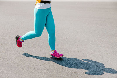 Low section of woman walking on road