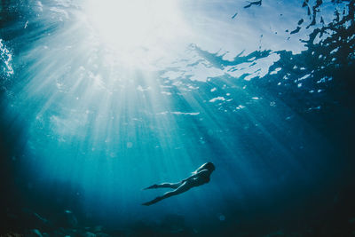 Low angle view of young woman swimming in sea