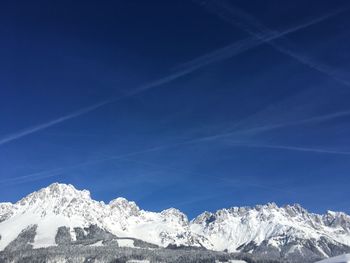 Scenic view of snowcapped mountains against blue sky