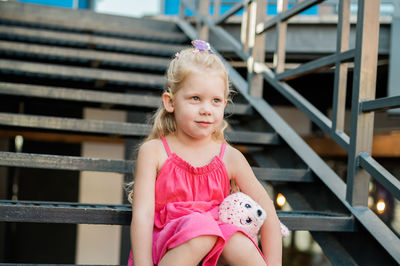 Portrait of cute girl standing against building