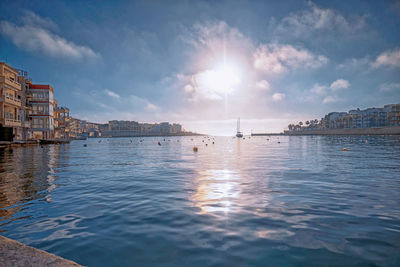 Scenic view of sea by buildings against sky