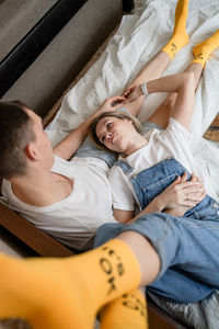 Portrait of young woman lying on bed at home