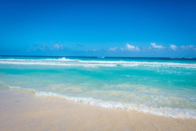 Scenic view of beach against blue sky