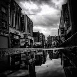 Buildings in city against cloudy sky