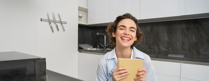 Portrait of young woman holding book