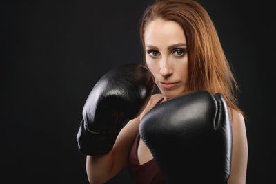 Portrait of woman against black background