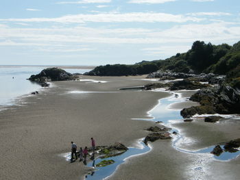 Family standing on sand at beach