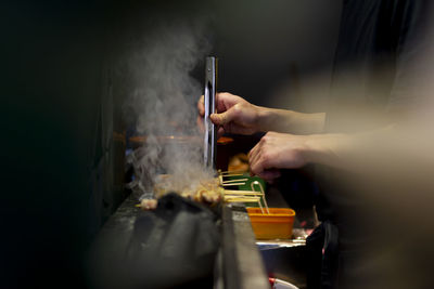 Asian chef preparing meat on grill