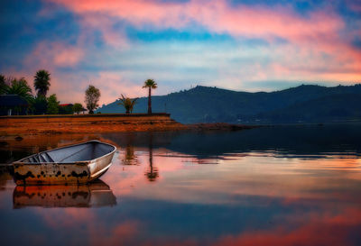 Twilight reflected in lake and a beached boat 