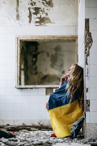 Low section of woman looking through window