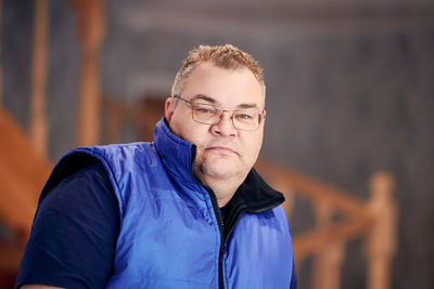 Portrait of young man standing against wall