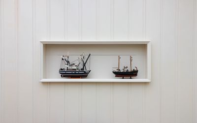 Boat on table against white wall