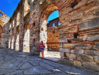 Woman standing by historical building