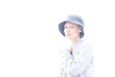 Portrait of young woman looking away against white background
