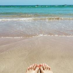 Low section of woman relaxing on beach