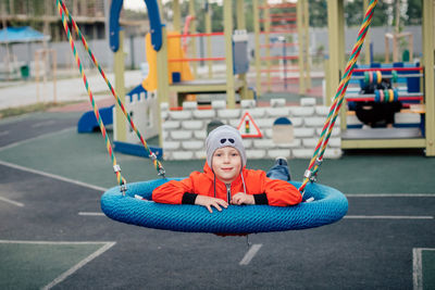 Young woman sitting on slide at playground