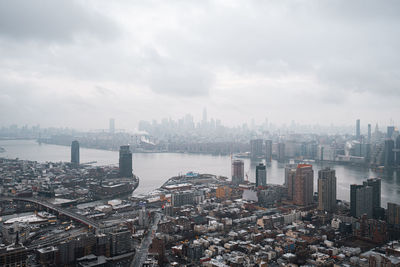Aerial view of buildings in city against sky