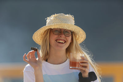 Portrait of a smiling young woman holding hat