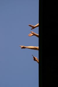Woman with arms raised against clear sky